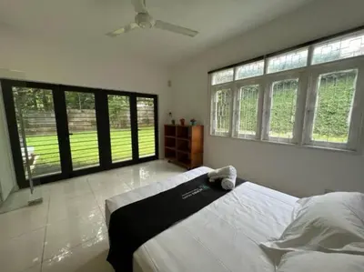 a bedroom with a large bed and large windows at KL PJ Garden Pool Villa Karaoke in Petaling Jaya
