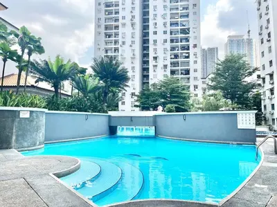 a blue swimming pool in a city with tall buildings at 3BR at Pantai HillPark near University Malaya Mid Valley in Kuala Lumpur