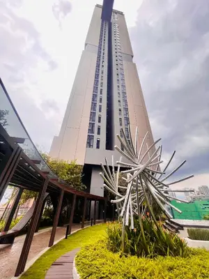 a tall building with a palm tree in front of it at Axon Residence Suites KL in Kuala Lumpur