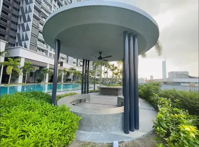a building with a fountain in front of a pool at Trion KL Premium Suite in Kuala Lumpur