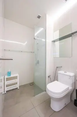 a white bathroom with a toilet and a glass shower at KL Sanctuary Style Comforts, Pool, Gym, Near MRT! in Kuala Lumpur