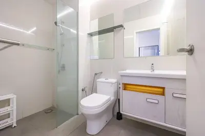 a white bathroom with a toilet and a sink at KL Sanctuary Style Comforts, Pool, Gym, Near MRT! in Kuala Lumpur