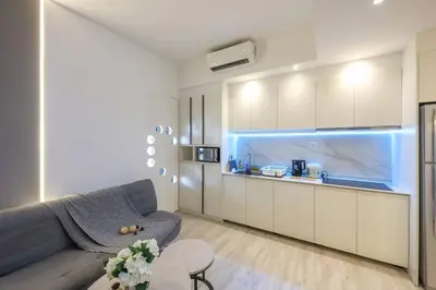 a living room with a couch and a kitchen at KL Sanctuary Style Comforts, Pool, Gym, Near MRT! in Kuala Lumpur