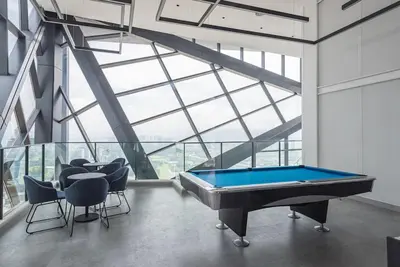 a pool table in a room with a large window at Charming Haven in Kuala Lumpur 100Mb TRX Mall in Kuala Lumpur