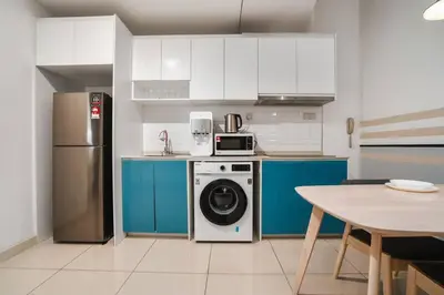 a kitchen with a refrigerator and a washing machine at Sleek 3BR Suites Near TRX By Rumabnb in Kuala Lumpur