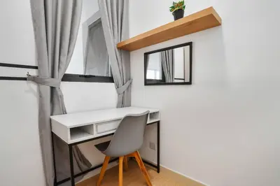 a desk and a chair in a room with a window at Sleek 3BR Suites Near TRX By Rumabnb in Kuala Lumpur