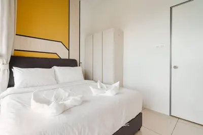 a large white bed with white sheets and pillows at 2Bedroom near TRX By RumaBnb in Kuala Lumpur