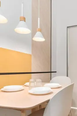 a table with white chairs and white plates and lights at 2Bedroom near TRX By RumaBnb in Kuala Lumpur