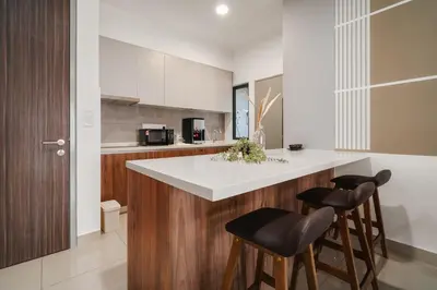 a kitchen with a counter and two bar stools at M Vertica Cheras by Xuites - 7 pax - Free Netflix - MRT at 500m - 15 mins to KLCC & TRX in Kuala Lumpur