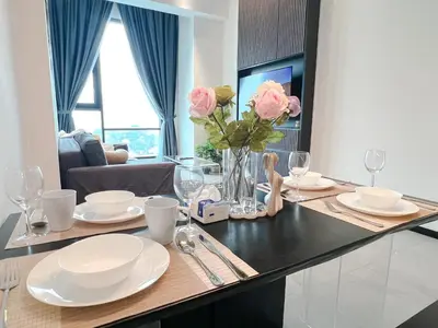 a dining room table with white plates and pink roses at OPUS Kuala Lumpur by Scape Stay in Kuala Lumpur