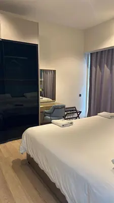 a bedroom with a large white bed and a chair at Star Residence KLCC By M&T in Kuala Lumpur
