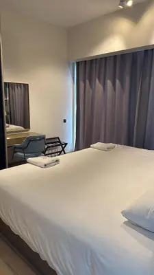 a bedroom with a large white bed and a chair at Star Residence KLCC By M&T in Kuala Lumpur