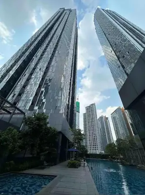 a tall building with a pool in front of a city at Star Residence KLCC By M&T in Kuala Lumpur