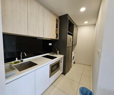 a kitchen with white cabinets and a sink at Pool Haven Reservations in Kuala Lumpur