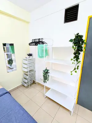 a white shelf with plants on it next to a bed at Private Room with Bathroom in Kuala Lumpur