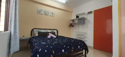 a bedroom with a bed with a blue comforter with a pink object on at Hostel Room with Private Bathroom in Kuala Lumpur