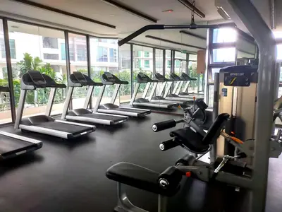 a gym with rows of tread machines in a row at 2-Bed Luxury Resort Robertson in Kuala Lumpur
