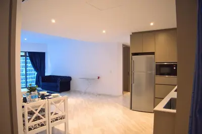 a kitchen and living room with a refrigerator and a table at Eaton Residence Yemala in Kuala Lumpur