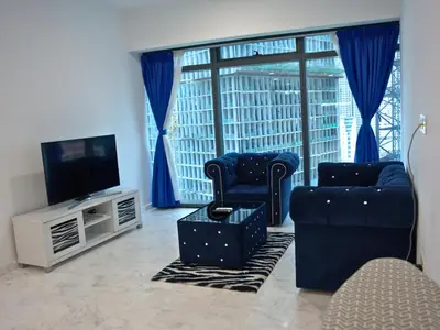 a living room with two chairs and a flat screen tv at Eaton Residence Yemala in Kuala Lumpur