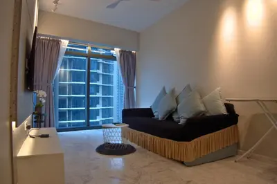 a living room with a couch and a large window at Eaton Residence Yemala in Kuala Lumpur