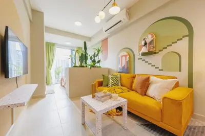 a living room with a yellow couch and a table at NaiBnB in The Colony by Infinitum in Kuala Lumpur