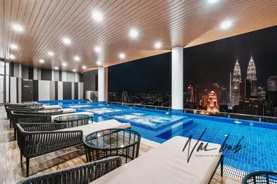 a pool with tables and chairs and a city skyline at NaiBnB in The Colony by Infinitum in Kuala Lumpur