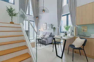 a room with a staircase and a kitchen and a living room at NaiBnB in The Colony by Infinitum in Kuala Lumpur