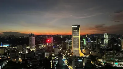 a city skyline at night with a tall building at The Robertson-Bukit Bintang by PILLOWTALKS in Kuala Lumpur