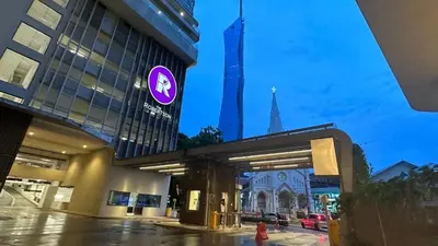 a building with a purple sign in front of a church at The Robertson-Bukit Bintang by PILLOWTALKS in Kuala Lumpur