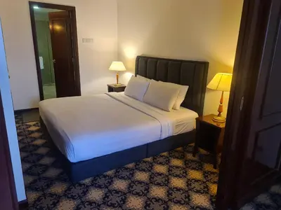 a bedroom with a bed with white sheets and two lamps at Soho Service Apartment at Times Square KL in Kuala Lumpur