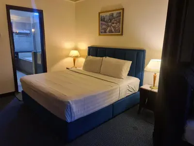 a bedroom with a large bed with a blue headboard at Soho Service Apartment at Times Square KL in Kuala Lumpur