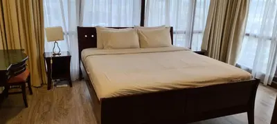 a large bed in a room with windows at Soho Service Apartment at Times Square KL in Kuala Lumpur