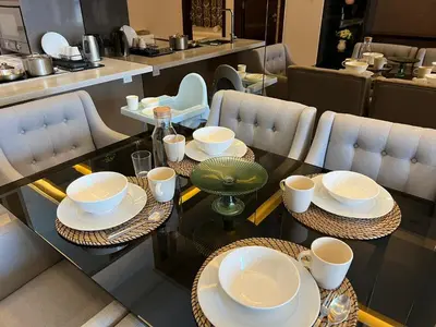 a table with plates and cups on top of it at Dorsett 2BR 6Pax Pavilion Bukit Bintang TRX KLCC in Kuala Lumpur