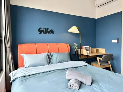 a bedroom with an orange headboard and a blue wall at M Vertica, Sunway Velocity Kuala Lumpur by Rverse Suite in Kuala Lumpur