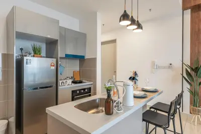 a kitchen with a sink and a stainless steel refrigerator at Trion Kuala Lumpur in Kuala Lumpur
