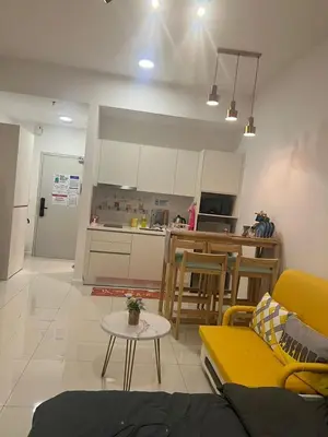 a living room with a yellow couch and a kitchen at Chambers Residence by Gloria Homes in Kuala Lumpur