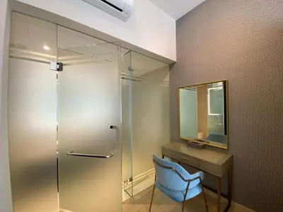 a bathroom with a glass shower and a blue chair at Star Resident KLCC By M&T in Kuala Lumpur