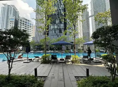 a pool with chairs and umbrellas in a city at Star Resident KLCC By M&T in Kuala Lumpur