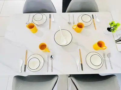 a white table with plates and cups and utensils at Arte Mont Kiara by DeUrban in Kuala Lumpur