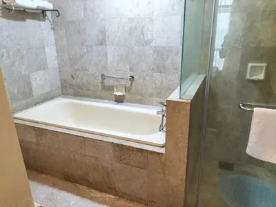 a bath tub in a bathroom with a shower at Bukit Bintang Service Suite at Times Square in Kuala Lumpur