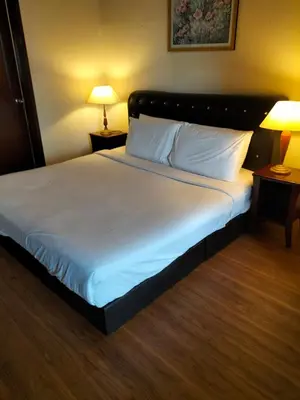 a large bed in a hotel room with two lamps at Bukit Bintang Service Suite at Times Square in Kuala Lumpur