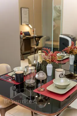 a table with plates and glasses and a bottle of wine at Dorsett Residences Sri Hartamas 5 Star Suites KL in Kuala Lumpur