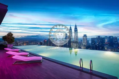 a swimming pool with pink chairs and a city skyline at HOME STYLE at Platinum Suites 2 KLCC Twin Towers in Kuala Lumpur