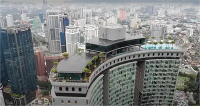 a large building with trees on top of it in a city at Sky Suites at KLCC by Mitstay in Kuala Lumpur