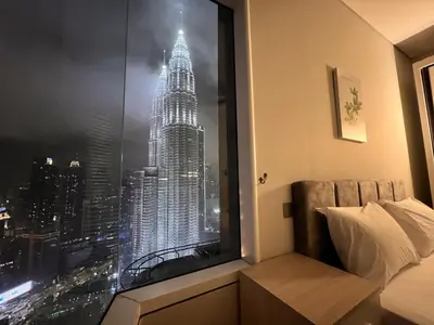a view of the empire state building from a bedroom window at Sky Suites at KLCC by Mitstay in Kuala Lumpur