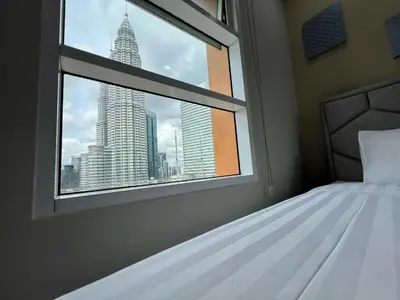 a bedroom with a window with a view of skyscrapers at Sky Suites at KLCC by Mitstay in Kuala Lumpur