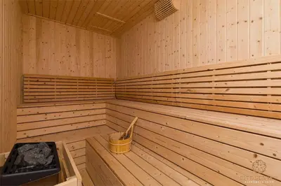 a wooden sauna with a tub and a bucket in it at The Manor Residence KLCC by Five Senses in Kuala Lumpur