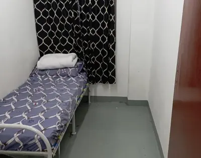 a small bed in a room with a curtain at Sri Rampai Metropolitan Hostel in Kuala Lumpur