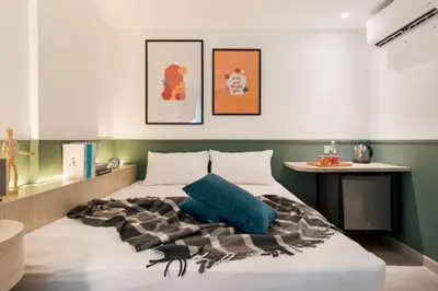 a bedroom with a bed with a blue pillow on it at Upstairs Downstairs CoLiving Bukit Bintang in Kuala Lumpur