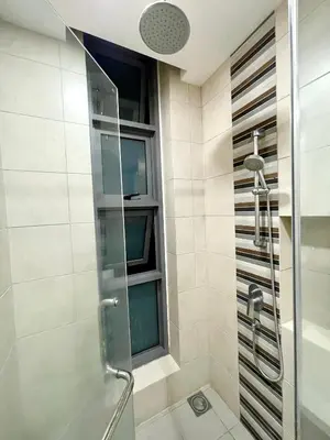 a shower with a glass door and a window at The Robertson Residence in bukit bintang in Kuala Lumpur
